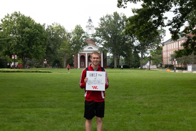 a man holding a sign in front of a building