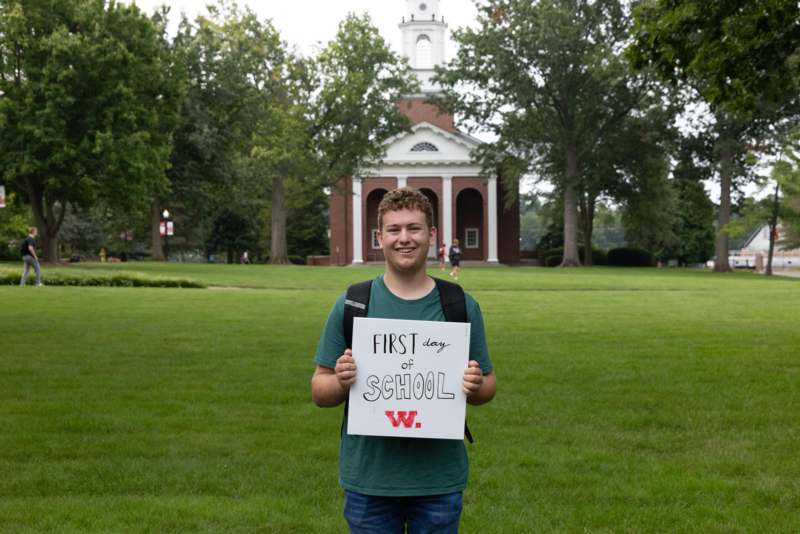 a man holding a sign in front of a building