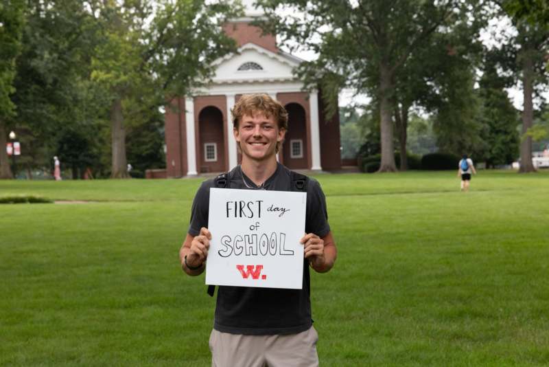a man holding a sign in front of a building