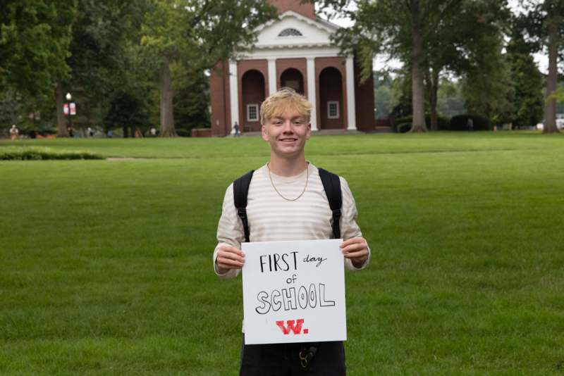a man holding a sign in front of a building