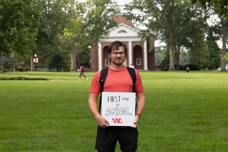 a man holding a sign in front of a building