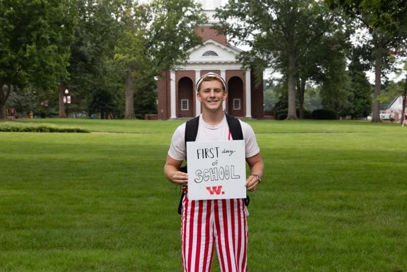 a man holding a sign in front of a building