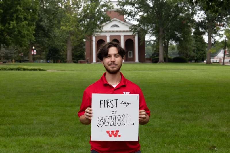 a man holding a sign in front of a building