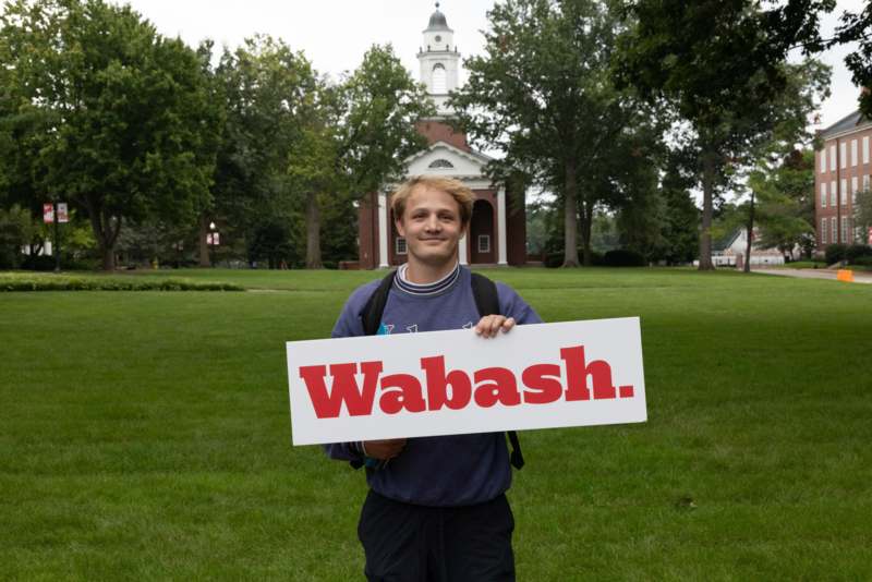 a man holding a sign in front of a building