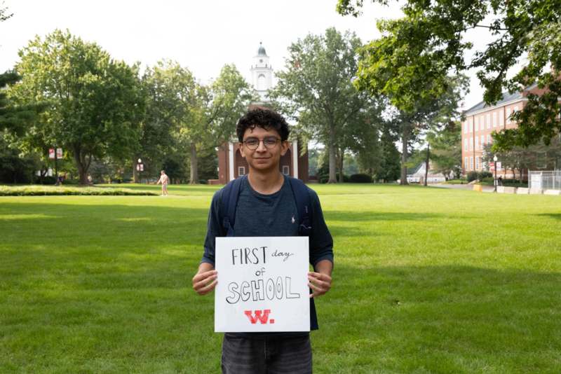 a boy holding a sign in front of a building