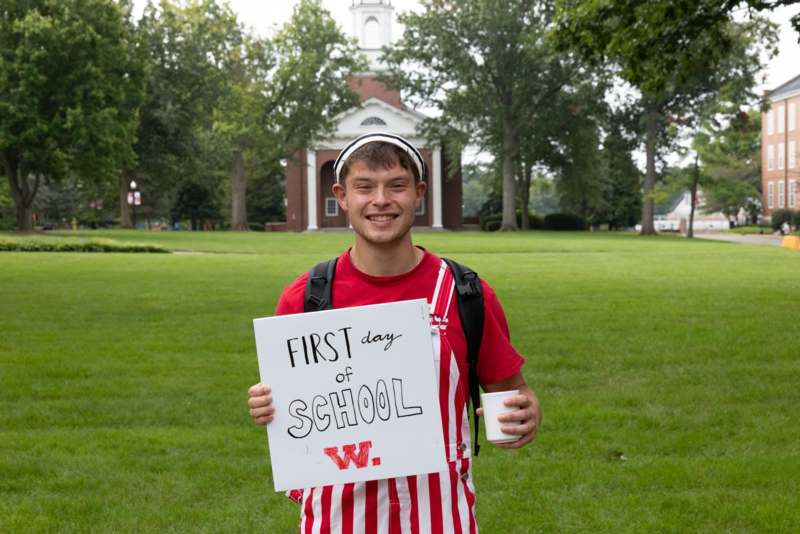 a man holding a sign in front of a building