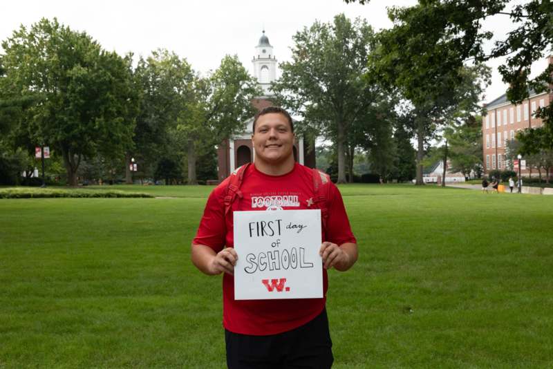 a man holding a sign in front of a building