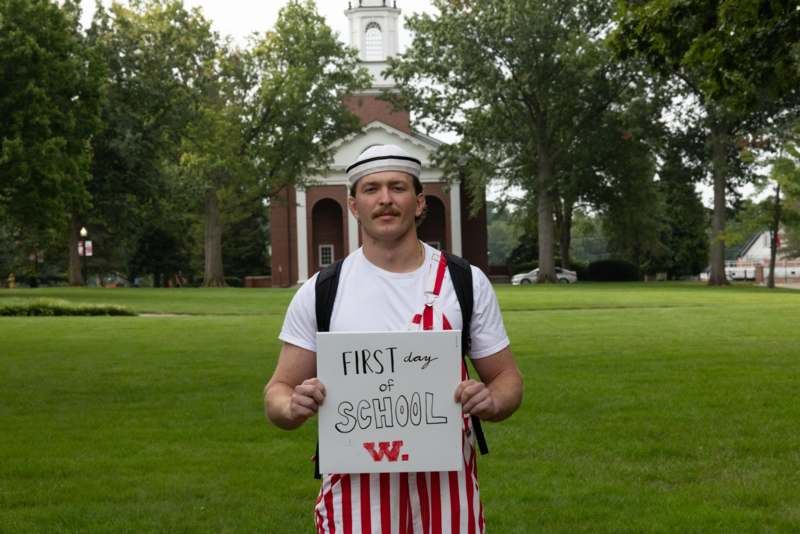 a man holding a sign in front of a building