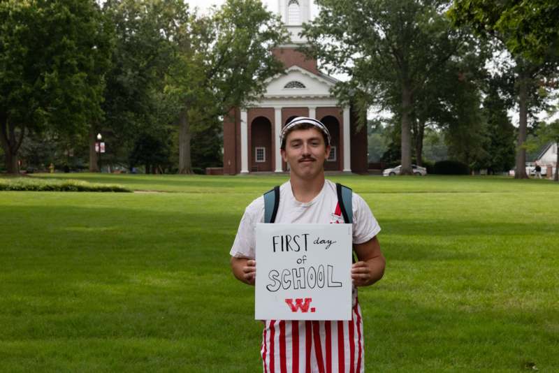 a man holding a sign in front of a building