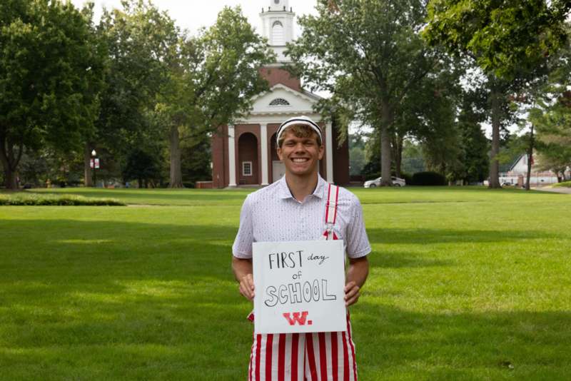 a man holding a sign in front of a building