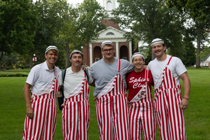 a group of men wearing striped overalls and hats