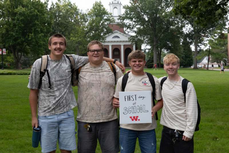 a group of boys standing in front of a building