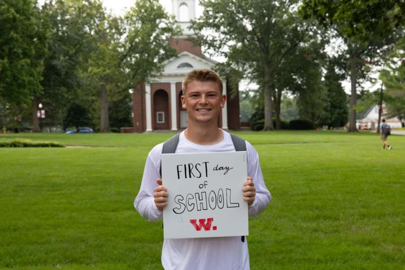 a man holding a sign in front of a building