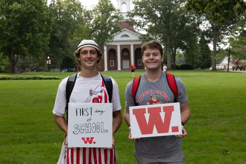 two men holding signs in front of a building
