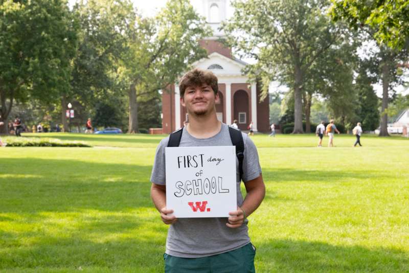 a man holding a sign in front of a building