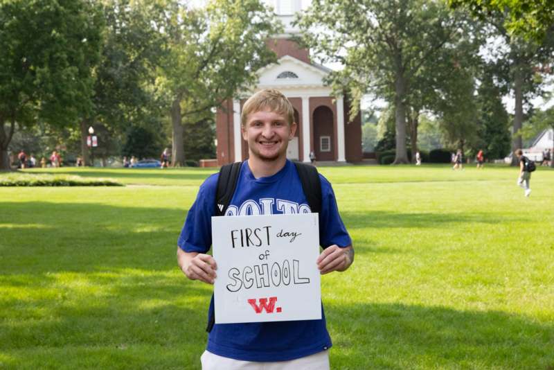 a man holding a sign in front of a building