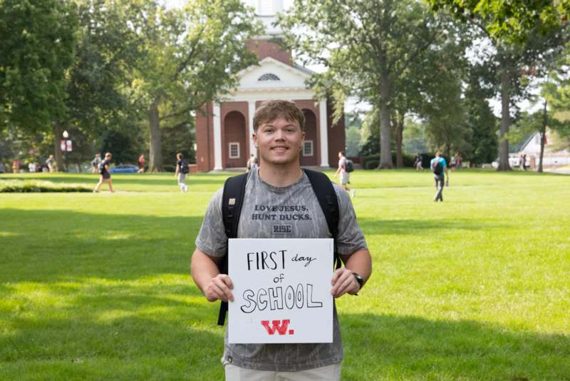 a man holding a sign in front of a building