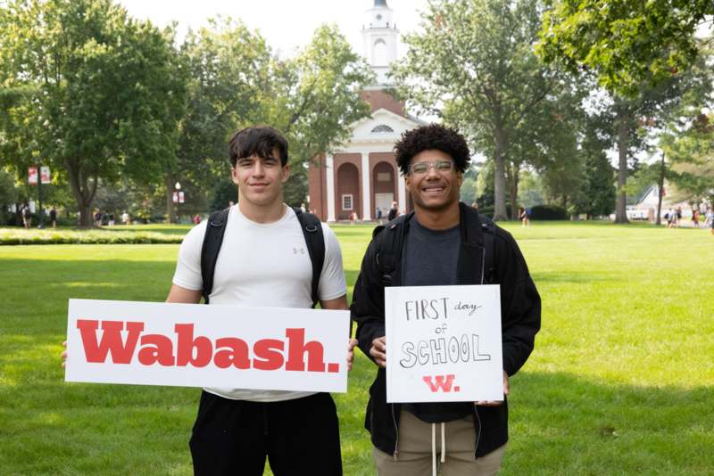 two men holding signs in front of a building