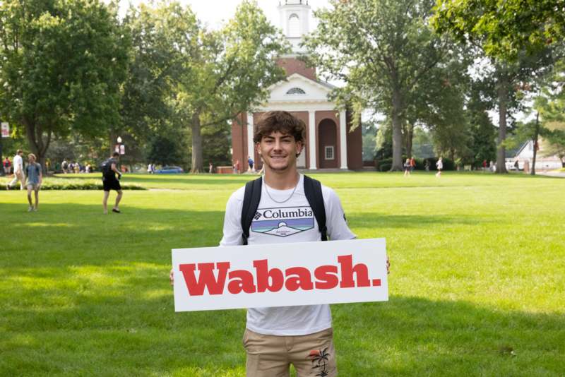 a man holding a sign in front of a building