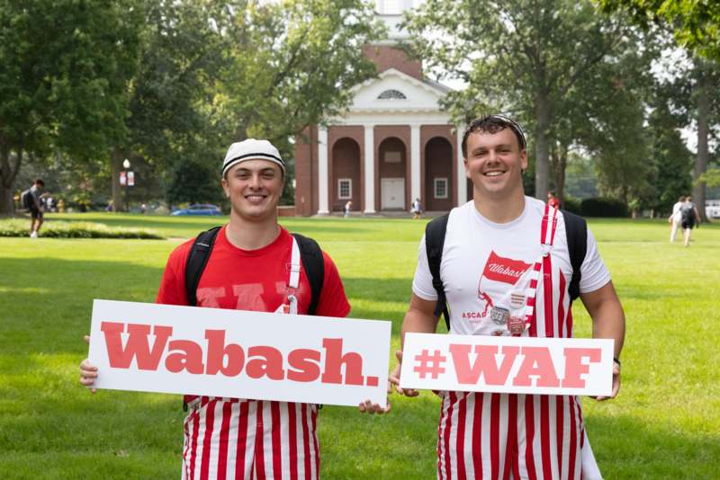 two men holding signs in front of a building