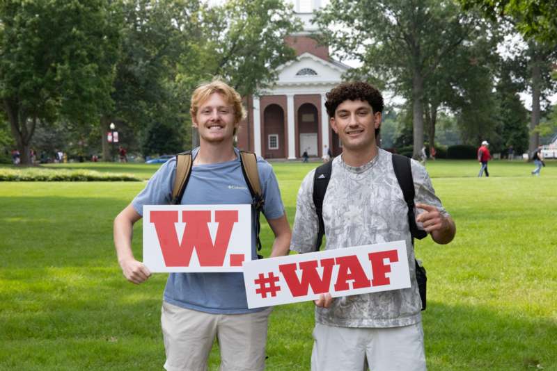 two men holding signs in front of a building