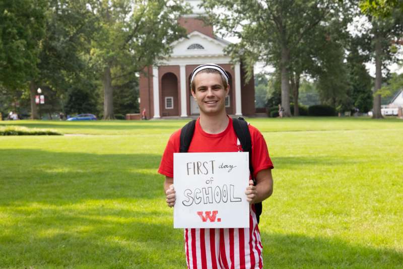 a man holding a sign in front of a building