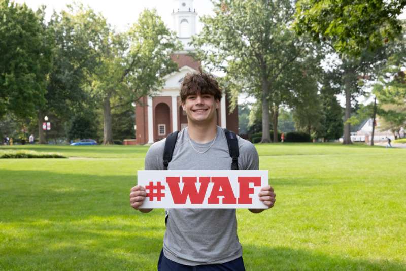 a man holding a sign in front of a building