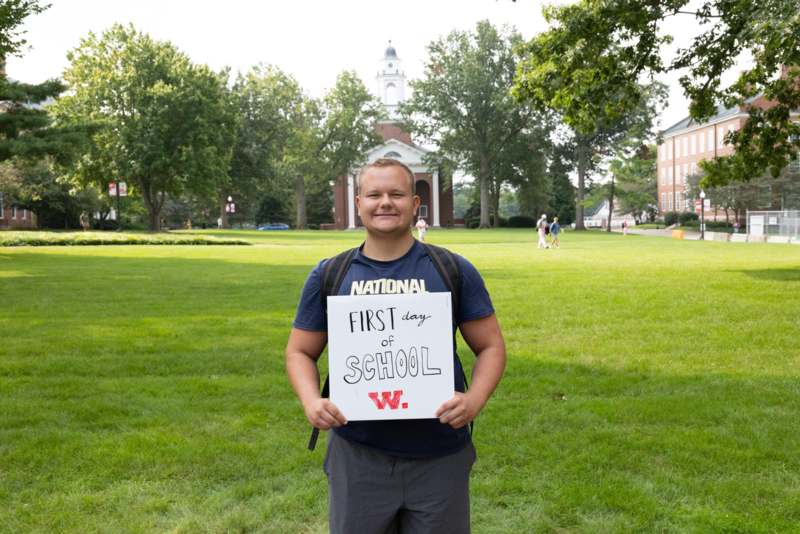 a man holding a sign in front of a building