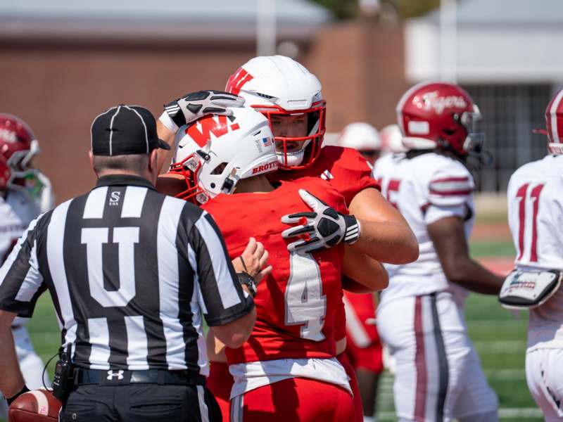a football player hugging another football player