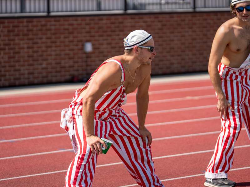 a group of men in striped overalls on a track