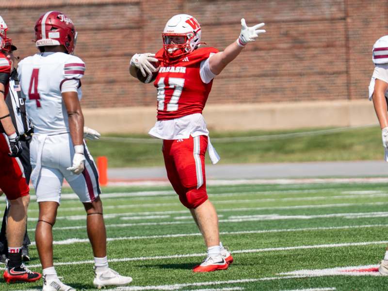 a football player in a red uniform holding a football