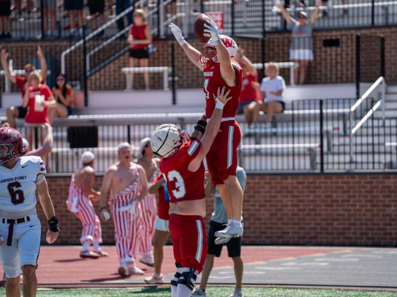 a football player jumping over another football player