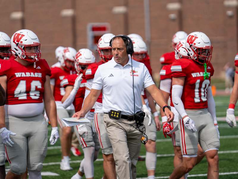 a football coach walking with his players