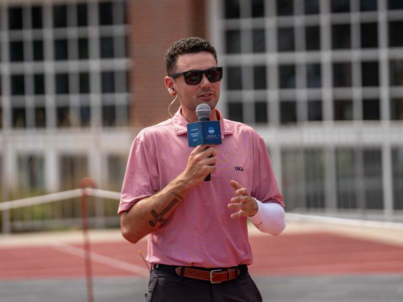 a man wearing sunglasses and holding a microphone