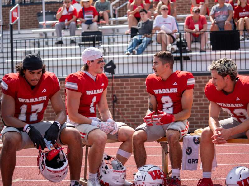 a group of football players sitting on benches