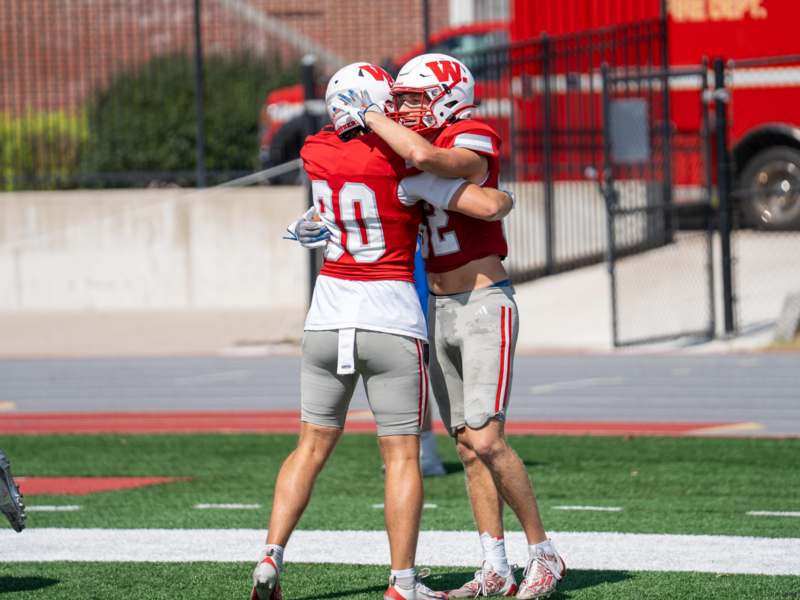two football players hugging on a field