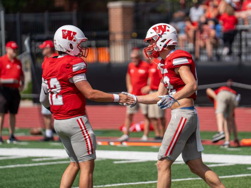 two football players shaking hands on a field