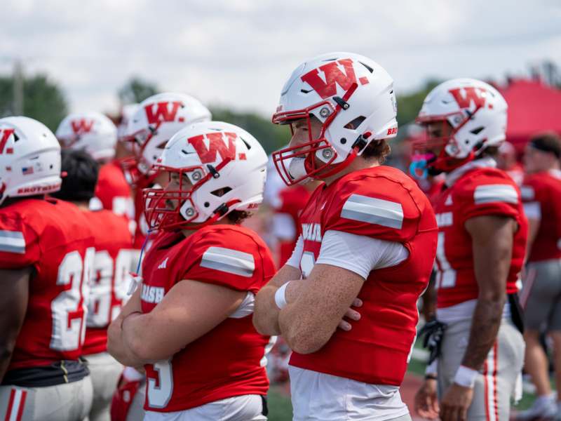 a group of football players in red and white uniforms