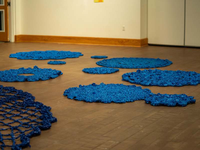a group of blue rugs on a wood floor
