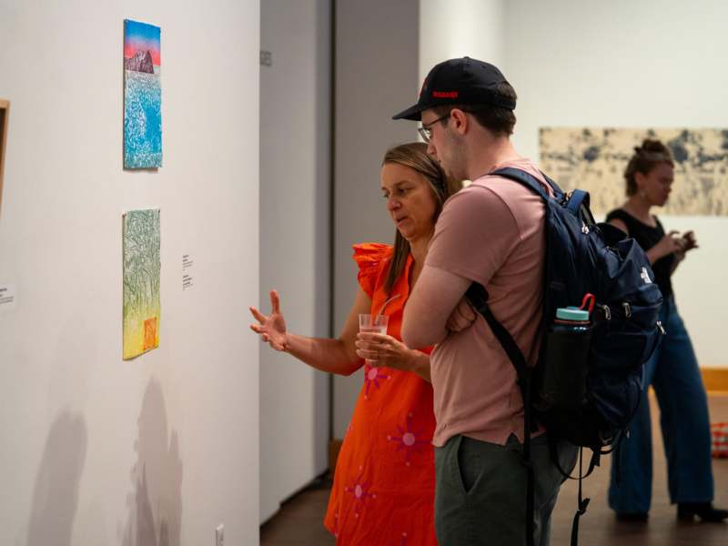 a man and woman looking at art on a wall