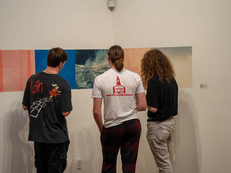 a group of people looking at a painting