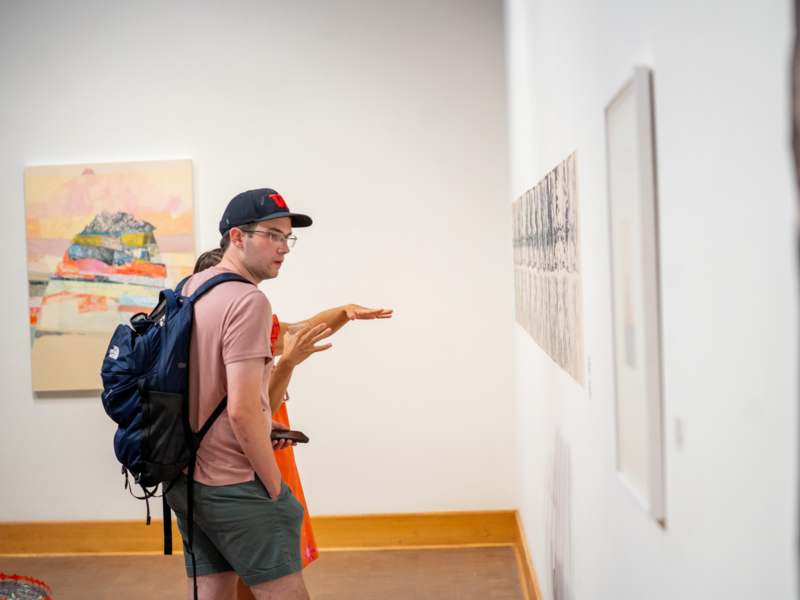 a man and woman looking at art on a wall