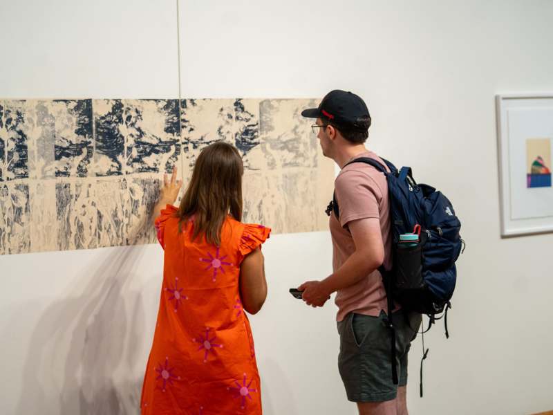 a man and woman looking at a piece of art