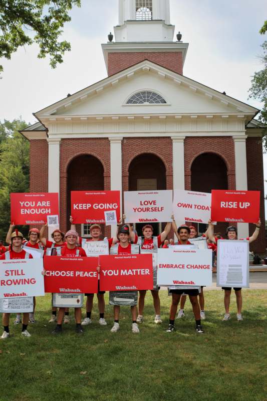 a group of people holding signs in front of a building