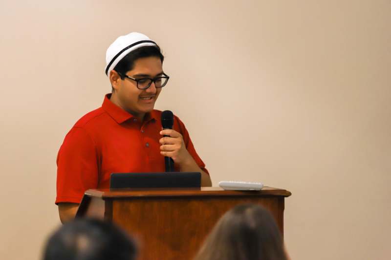 a man standing at a podium holding a microphone