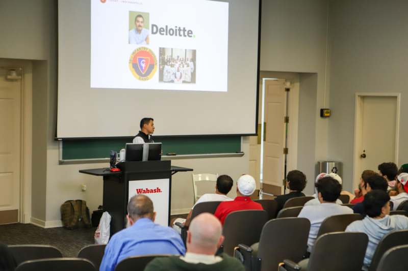 a man standing at a podium giving a presentation