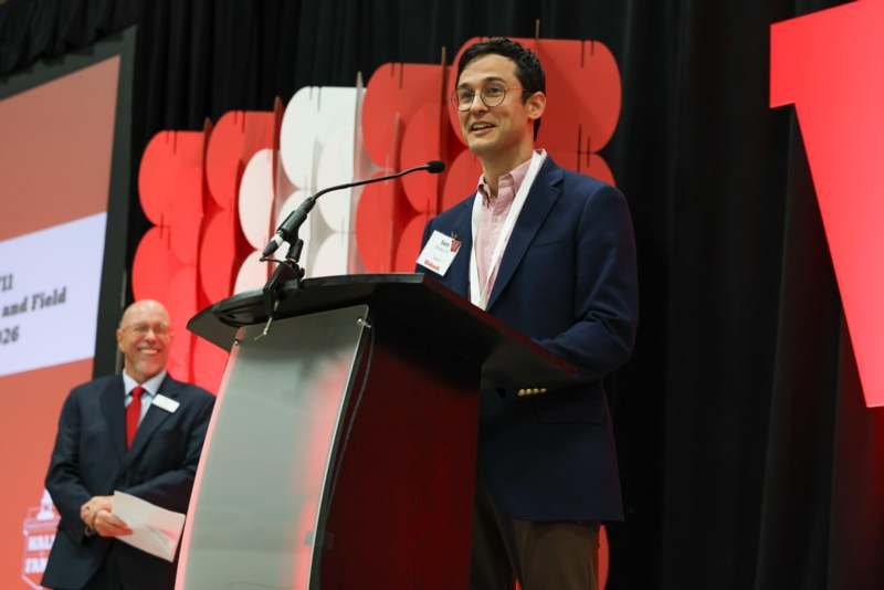 a man standing at a podium with a microphone