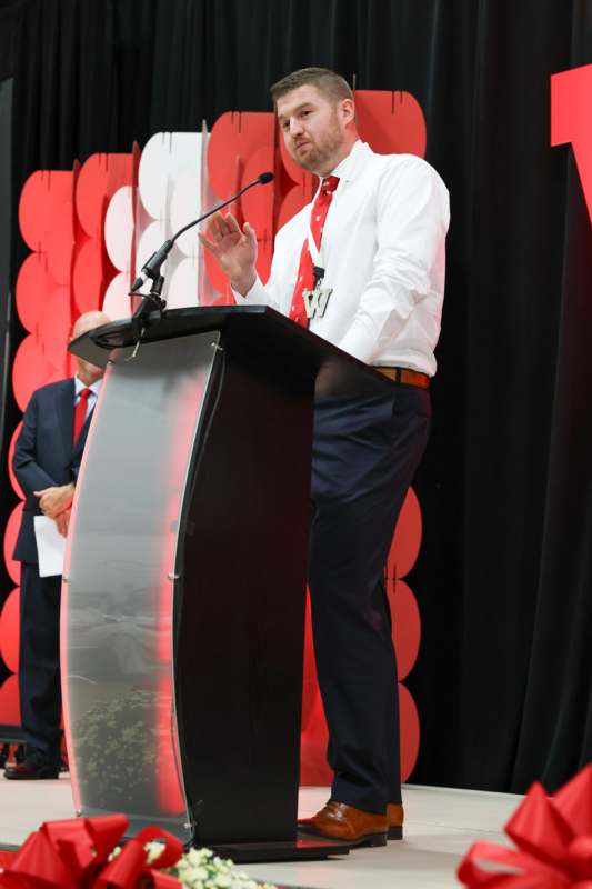 a man standing at a podium with a microphone