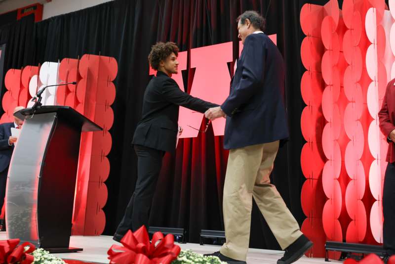 a man shaking hands with another man on a stage