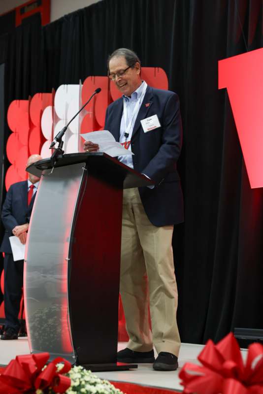 a man standing at a podium with a microphone